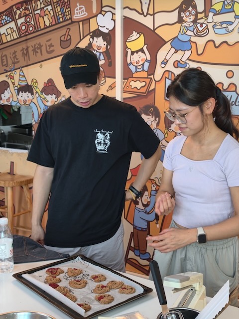 Jason and Viann baking together, with a tray of cookies